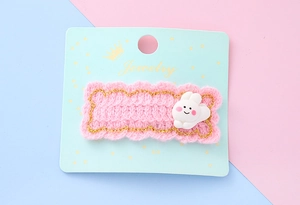 Détails d'une pince à cheveux tricotée rose avec un lapin mignon et des fils dorés