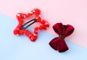 Détail de la pince à cheveux étoile rouge et du nœud en velours pour set d'accessoires