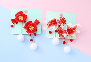 Close-up of traditional Chinese New Year hair clips with koi fish and luck pouch details