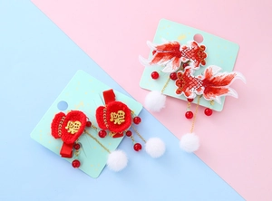 Close-up of traditional koi and lucky bag hair clips with embroidery and tassels