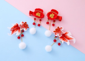 Detailed view of festive red fortune bag and koi fish hair clips with soft tassels