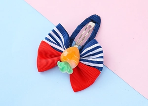 Detail of red and blue striped ribbon hair clip with resin carrot charm for girls