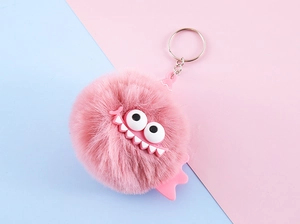 Detail view of pink plush monster keychain with large eyes and a silver metal ring