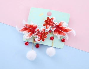 Detailed embroidery of festive red koi fish hair clips with soft white pom poms for girls
