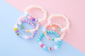 Detail of colorful macaron beaded bracelets with pearls and cracked beads for girls