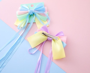 Detail of multi-layer macaron bow hair clip with long ribbons and metal duckbill clip