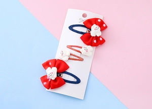 Dettaglio di un set da 4 mollette a fiocco rosso a pois con piccoli coniglietti carini