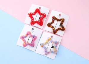 Lot de quatre barrettes en forme d'étoile en maille colorée avec texture pompon douce