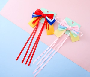 Detail view of colorful bow hair clips with long satin streamers on a display card