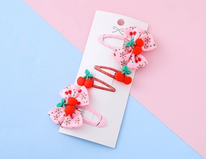 Dettaglio del set di 3 fermagli per capelli con ciliegie per bambini su scheda display