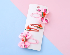 Dettaglio del set fermagli per capelli bimba con fiocchi anguria e glitter