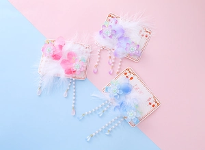 Detail of handmade tassel hair clips with gradient flowers, feathers and crystal beads