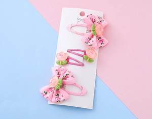 Dettaglio set 4 mollette per bambini con fiocchi floreali e tulipani su scheda di supporto