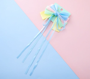 Detailed set of macaron-colored silk bow hair clips with long streamers on a display card