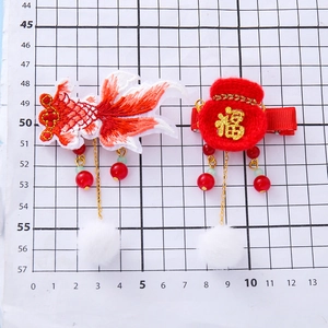 Chinese New Year koi and lucky bag hair clips with tassels for kids on a grid scale background