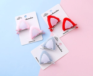 Detalle de pinzas para el pelo con orejas de gato de felpa en rosa rojo y gris