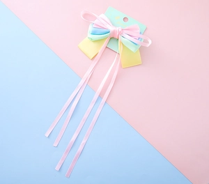 Detail of sweet macaron layered ribbon hair clip with long hanging streamers for girls