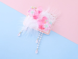 Detail of pink floral hair clips with white feathers and long pearl tassels