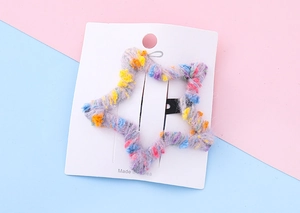 Vue détaillée de la barrette étoile pour enfants avec texture en laine tricotée colorée