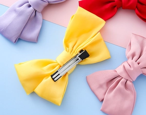 Detailed view of colorful fabric bow hair clips with sturdy metal alligator clasps