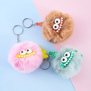 Fluffy faux fur monster keychains in pink, tan, and mint green with quirky big eyes