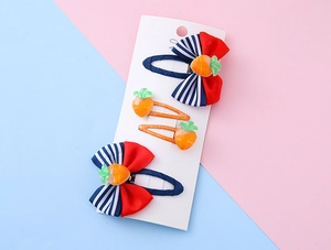 Dettaglio di set 4 mollette per capelli bimba con fiocchi a righe e decoro carota