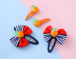 Vista dettagliata del set di 4 fermagli per capelli per bambini con carote e fiocchi
