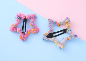 Gros plan de barrettes étoile en tricot avec textures de fils colorés et pinces crocoqs