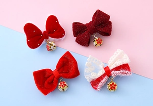 Close-up of assorted red bow hair clips with festive bells and lace details