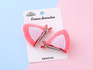 Detalle de pinzas para el pelo con orejas de gato en felpa rosa y clip metálico resistente