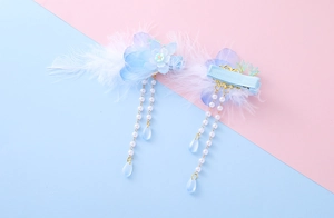 Detail of blue silk flower hair clips with soft feathers and long pearl tassel beads