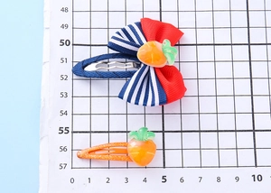 Dettaglio del fermaglio a fiocco per bambini con carota e clip arancione glitterata
