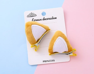 Detalle de pinzas para el pelo con orejas de gato de felpa amarilla y clips de metal