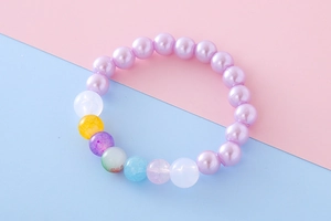 Detailed view of girls purple faux pearl bracelet with colorful accent beads for children