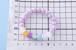 Detailed top view of colorful beaded girl bracelet on grid scale measurement paper
