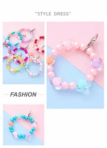 Macro shot of colorful macaron beads and transparent heart charms on beaded chains
