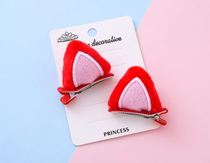 Detalle de pinzas para el cabello con orejas de gato de felpa roja y rosa con clips de metal
