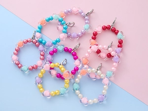 Close-up of colorful heart beads and pastel pearls on a handmade beaded keychain charm