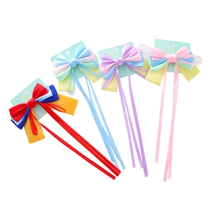 Set of four colorful satin bow hair clips with long ribbons on display cards