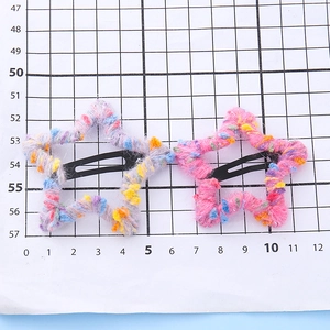 Pinces à cheveux étoiles pour enfants avec laine colorée sur fond de grille graduée