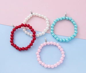 Close-up van parelkraal ring charms in wit, rood, blauw en roze met zilveren metalen sluitingen