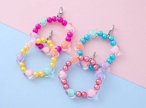 Macro detail of colorful beaded heart charms with silver lobster clasps for bags or keys