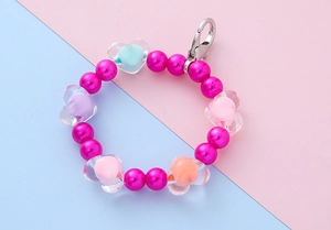 Detailed macro of colorful heart beads and magenta round beads for children keychain