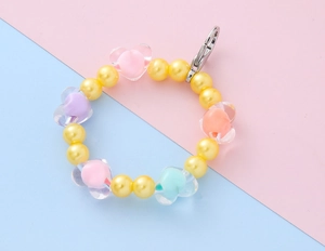Detail of colorful heart-shaped beads and yellow pearls with a silver spring clasp