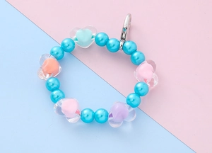 Close-up of blue pearlescent beads and transparent heart charms on a colorful pendant