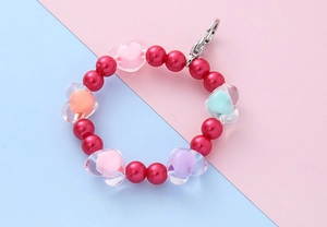 Detailed shot of dark red pearls and colorful transparent heart beads with silver metal clasp