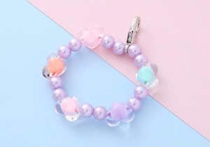 Detail of macaron beaded charm with purple pearls, colorful hearts and silver lobster clasp