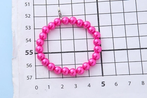 Macro-detail van de levendige roze parelarmband met een zilveren karabijnsluiting erop