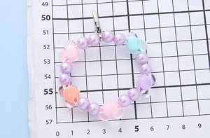 Detail of colorful beaded charm with heart beads and silver lobster clasp for bags
