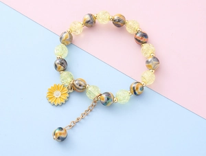 Detail der gelben Sonnenblume am Perlenarmband mit bunten floralen Anhängern